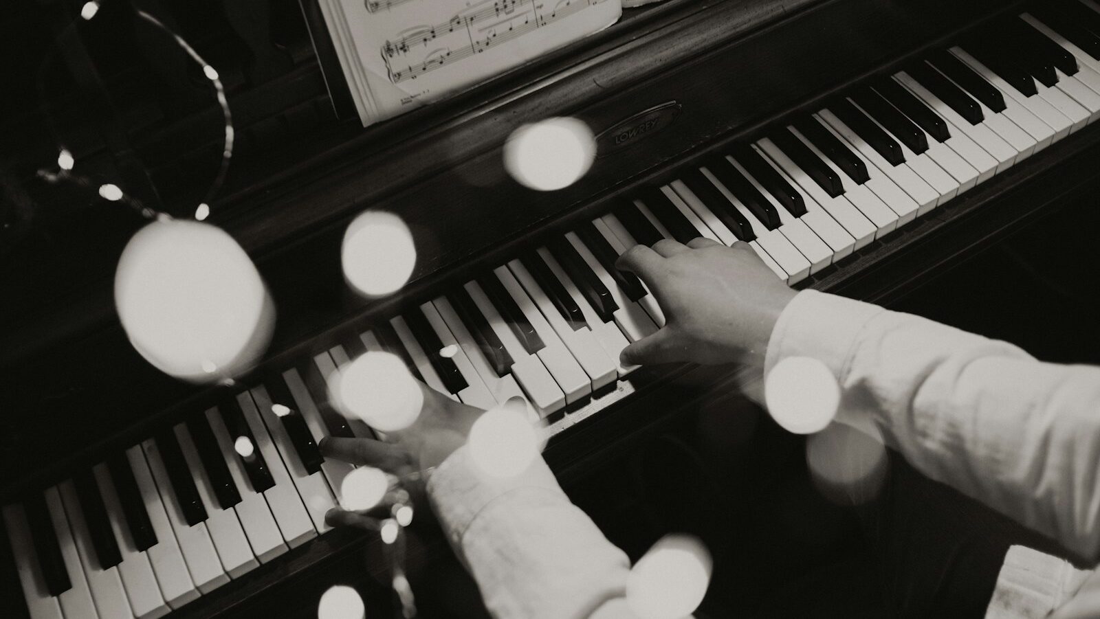 person playing piano in grayscale photography