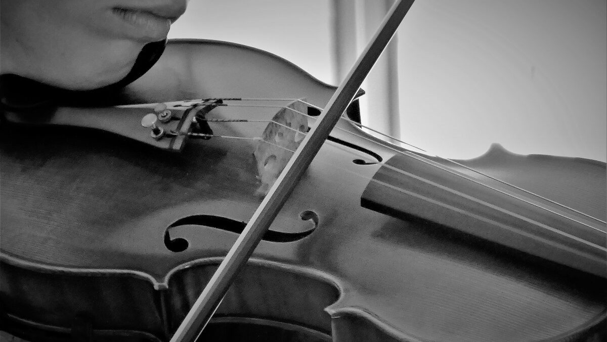 person playing piano in grayscale photography