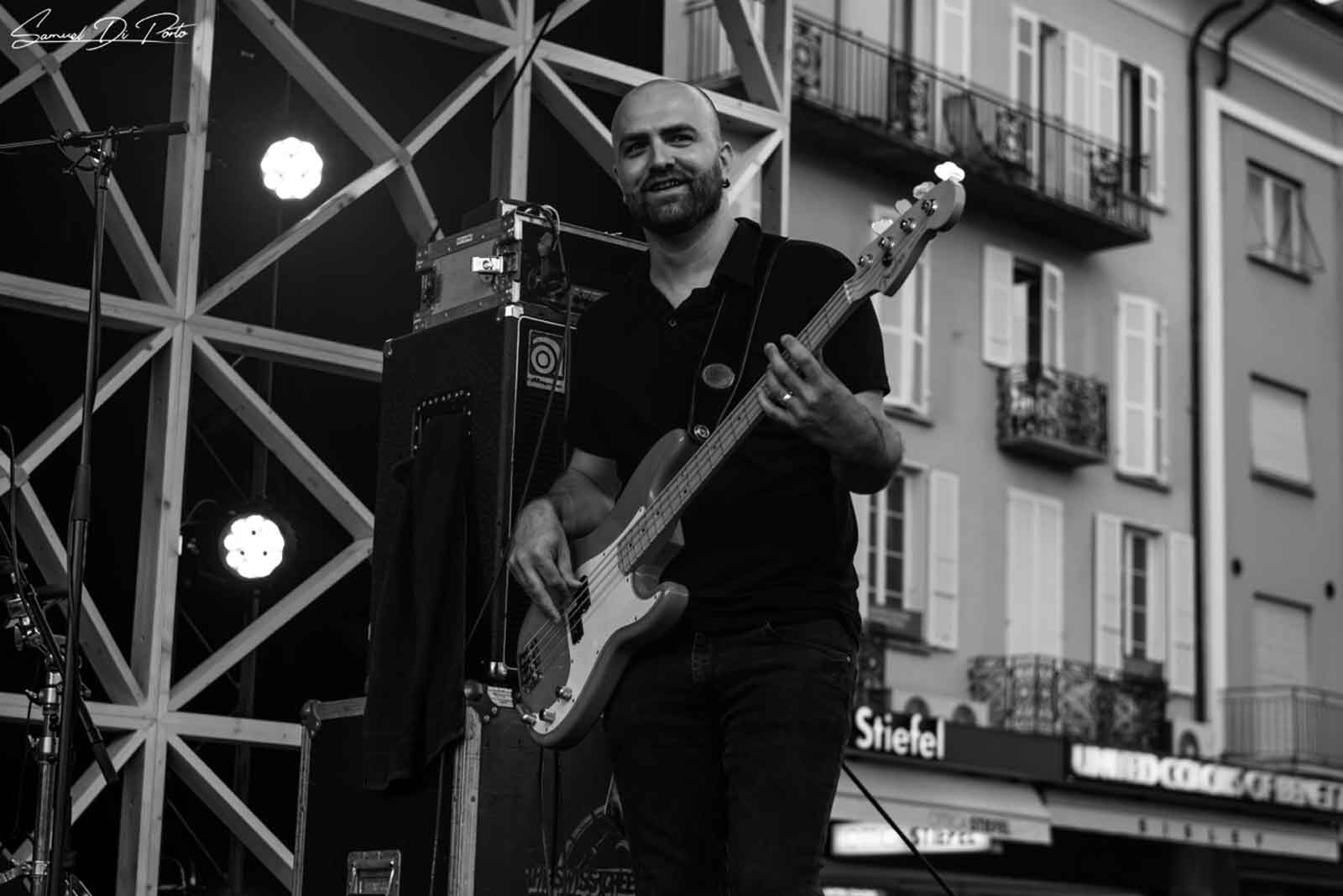 grayscale photography of person carrying guitar