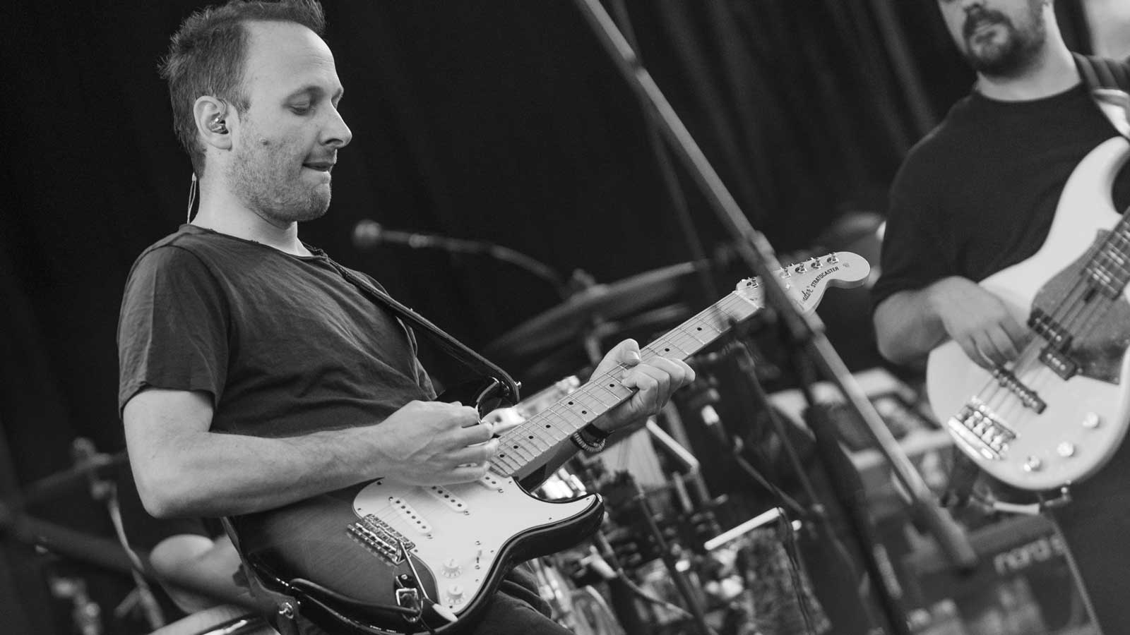 man playing guitar beside woman in black t-shirt