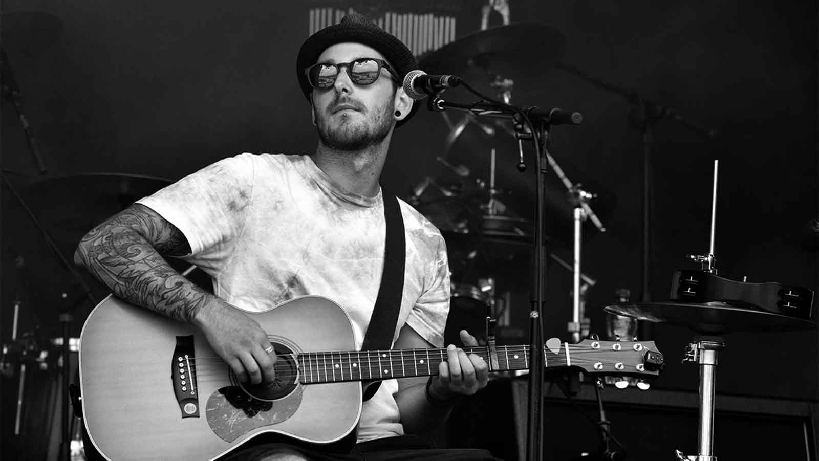 man playing guitar beside woman in black t-shirt