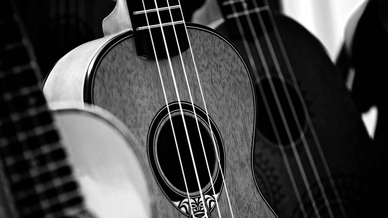 grayscale photography of person carrying guitar